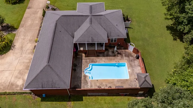 a view of house with garden and tall trees