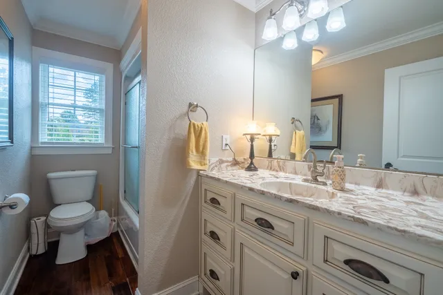 a bedroom with a bed and a large window with wooden floor