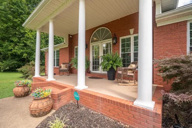 a view of a patio with couches table and chairs and potted plants