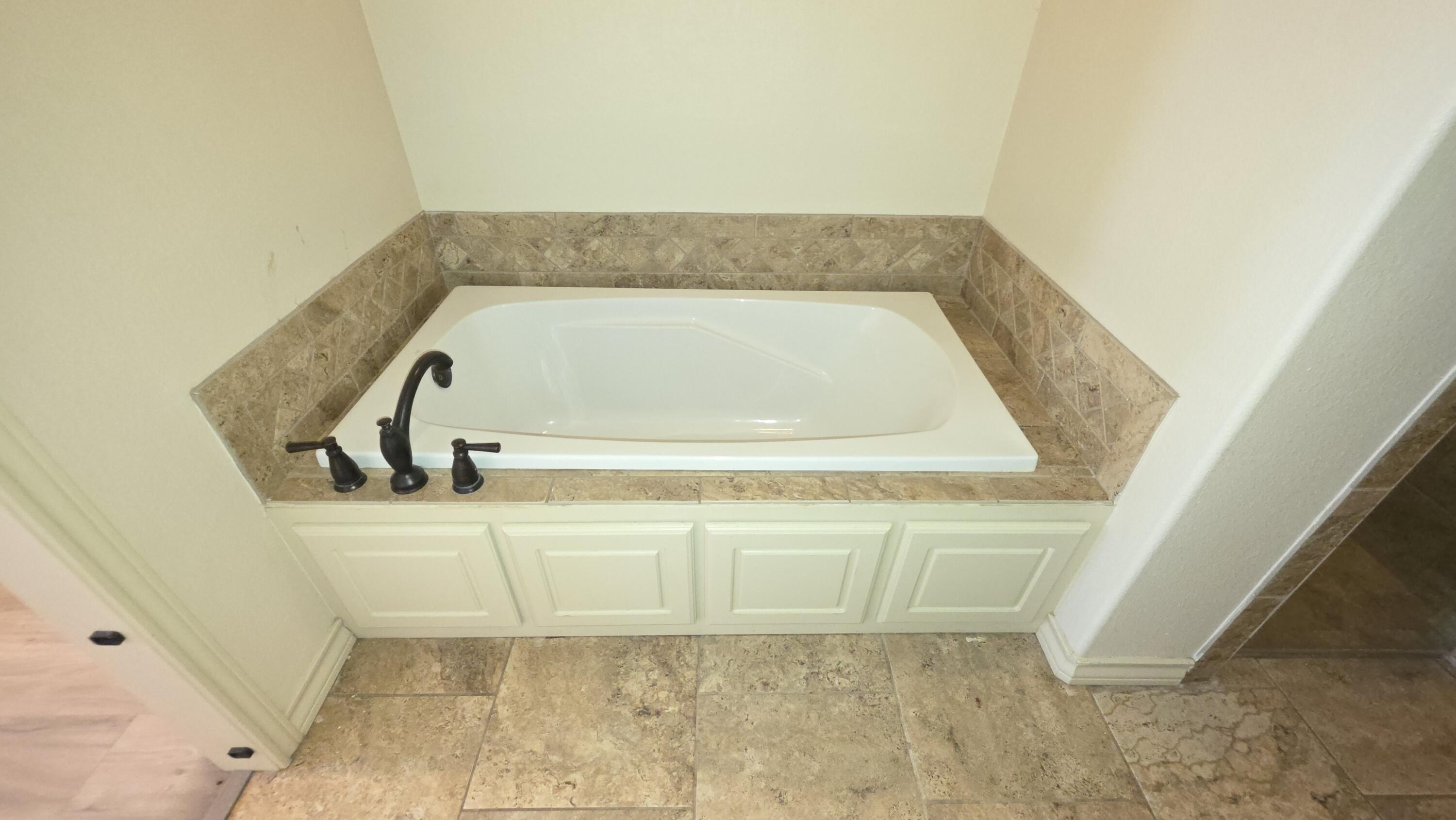 5234 Kemper Street Lubbock, TX 79416 - Photo 14 of 28 a bathroom with a tub
