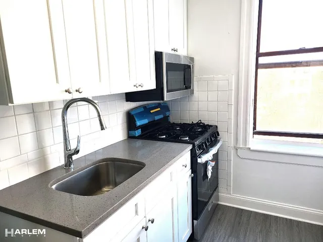 a kitchen with a sink and a stove next to a window