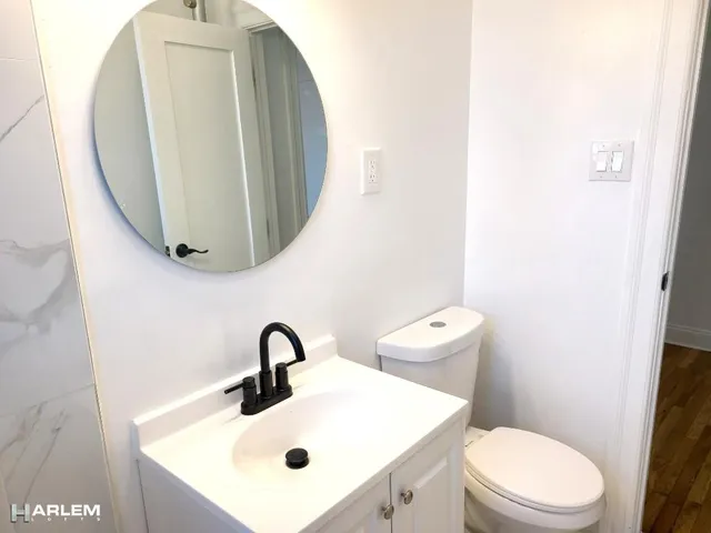 a bathroom with a toilet sink and mirror