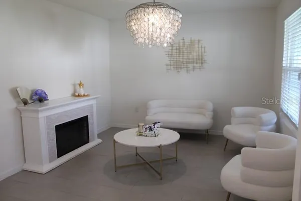 a living room with furniture a chandelier and a fireplace