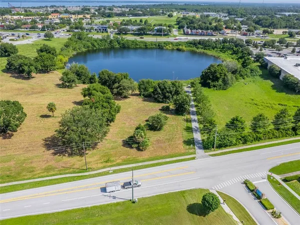 an aerial view of a residential houses with outdoor space and lake view in back