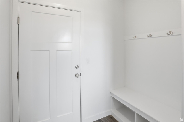 3636 West 910 South Syracuse, UT 84075 - Photo 24 of 70 Entryway featuring a white paneled door with brushed nickel hardware, built-in white bench with storage cubbies, and a wall-mounted coat rack