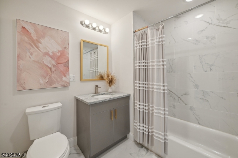 45 South Grove Street, Unit 232 East Orange, NJ 07018 - Photo 9 of 22 a bathroom with a granite countertop sink toilet and shower