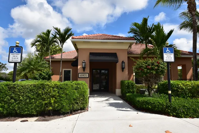 a front view of a house with a fountain in front of house