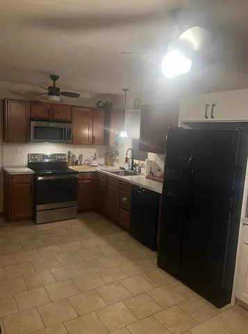 a living room with stainless steel appliances furniture and a kitchen view