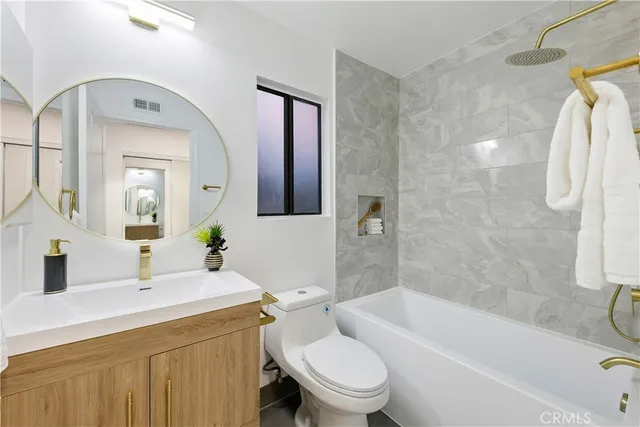 a bathroom with a toilet sink vanity tub and shower