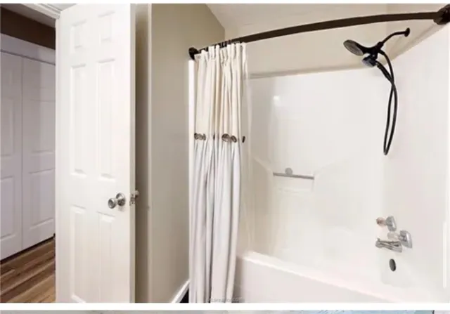 a bathroom with a shower and a bath tub