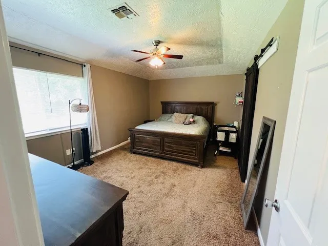 a spacious bedroom with a bed and a chandelier