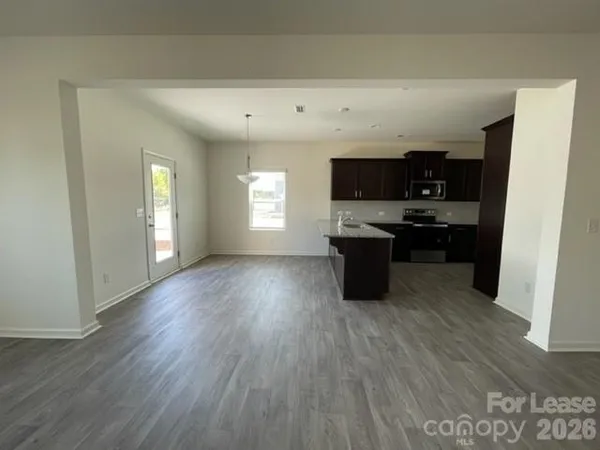 a kitchen with kitchen island granite countertop a stove top oven a sink and a microwave