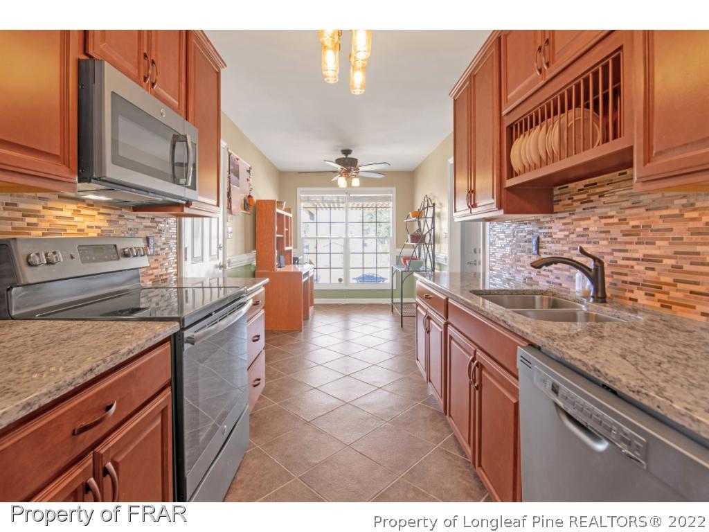 361 Camden Road Raeford, NC 28376 - Photo 11 of 36 a kitchen with stainless steel appliances granite countertop a sink stove and cabinets