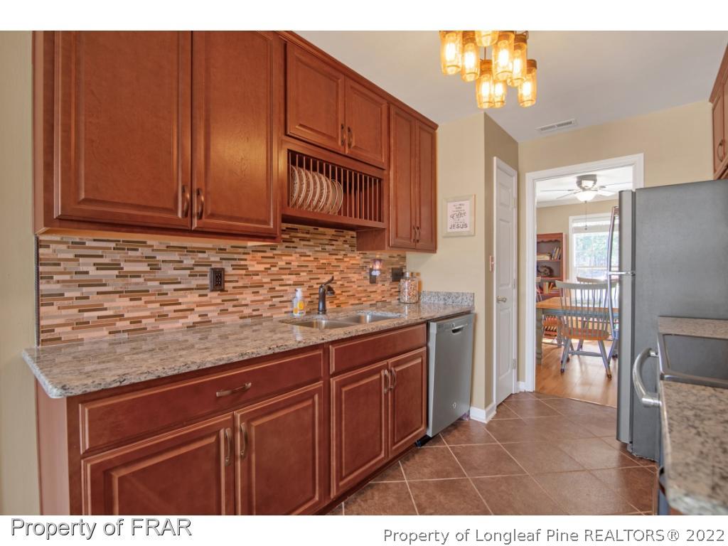 361 Camden Road Raeford, NC 28376 - Photo 12 of 36 a kitchen with stainless steel appliances granite countertop a sink stove and refrigerator