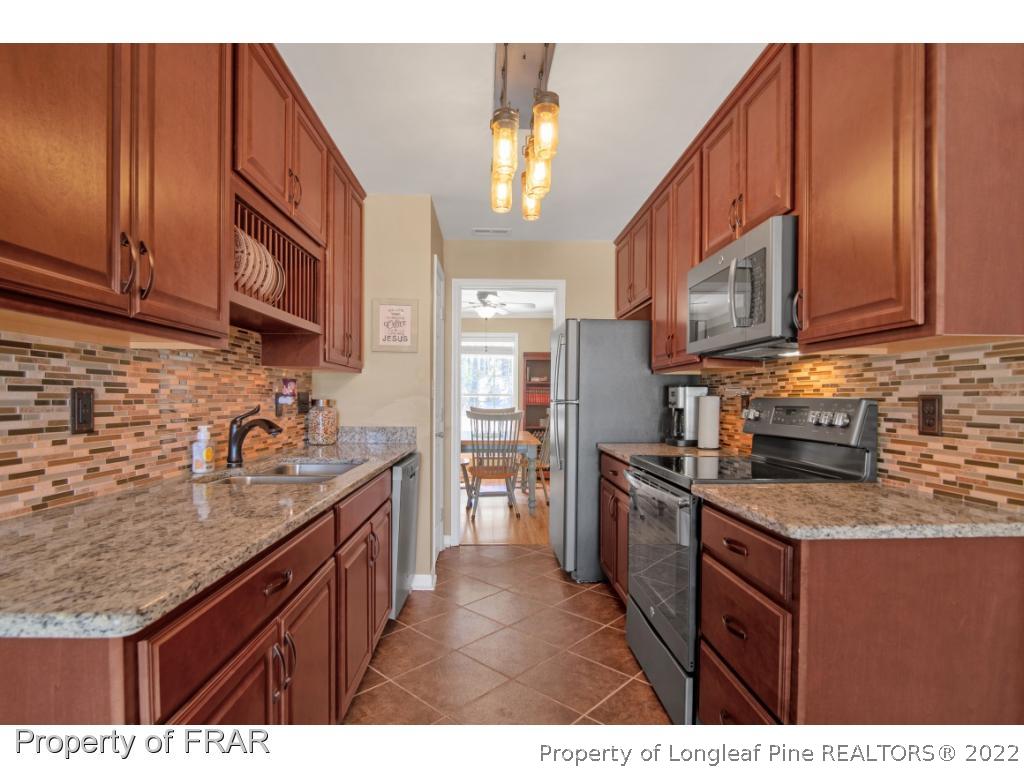 361 Camden Road Raeford, NC 28376 - Photo 13 of 36 a kitchen with stainless steel appliances granite countertop a sink stove and cabinets