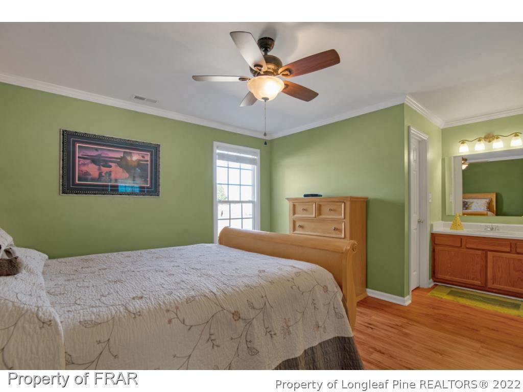 361 Camden Road Raeford, NC 28376 - Photo 17 of 36 a bedroom with a large bed and a chandelier