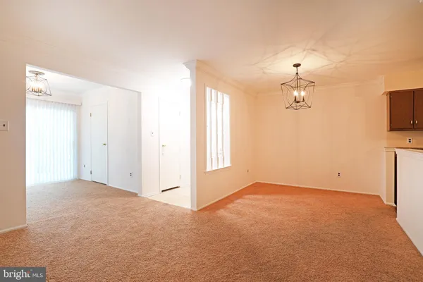 en empty room with windows and chandelier