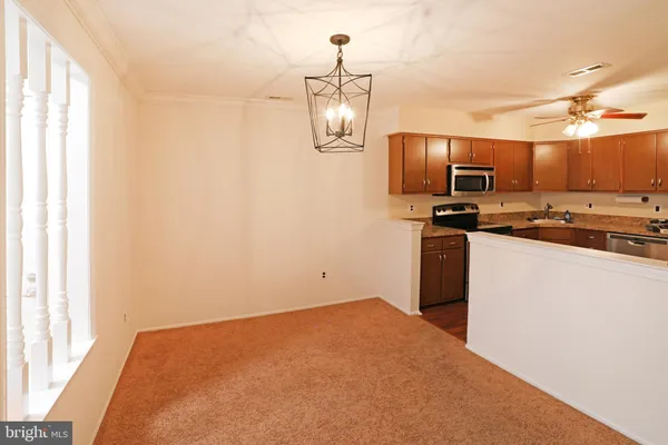 a kitchen with stainless steel appliances granite countertop a stove a sink and a refrigerator with wooden floor