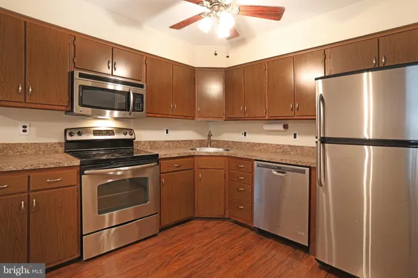 a kitchen with stainless steel appliances granite countertop a refrigerator stove a sink and a microwave