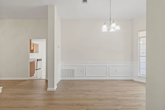 a view of empty room with wooden floor and ceiling fan
