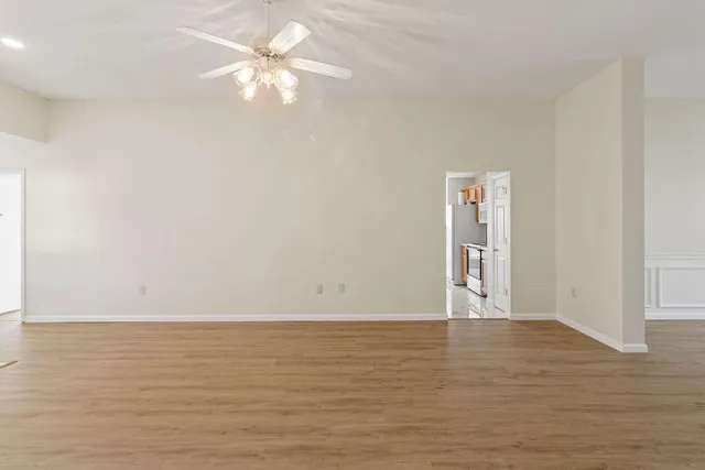 a view of an empty room with window and a ceiling fan