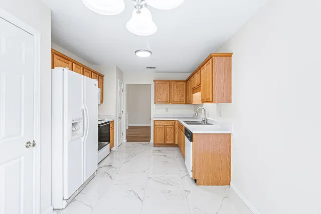 a kitchen with stainless steel appliances a stove refrigerator sink and cabinets