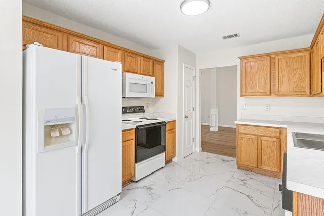 a kitchen with stainless steel appliances granite countertop a refrigerator and a stove top oven