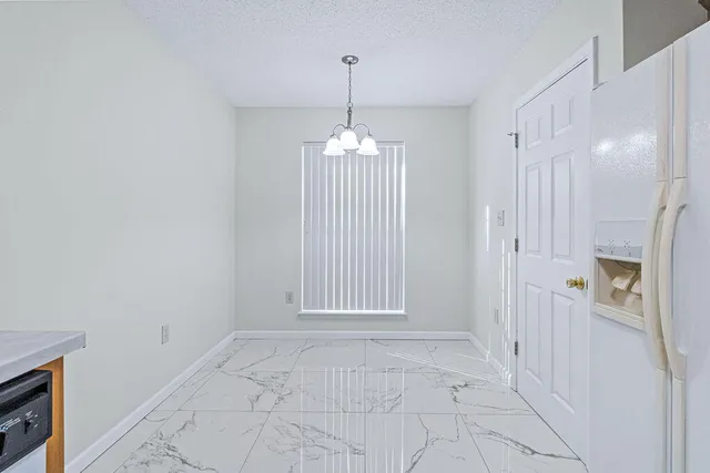 a view of a hallway with windows and chandelier