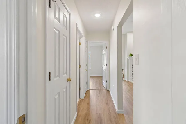a view of a hallway with wooden floor and staircase