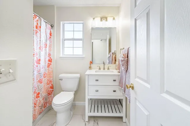 a bathroom with a toilet a sink and a window