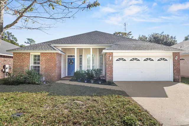 a front view of a house with a yard and potted plants