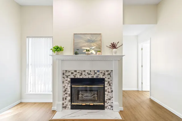a living room with a fireplace and wooden floor