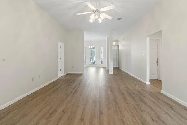 a view of an empty room with wooden floor