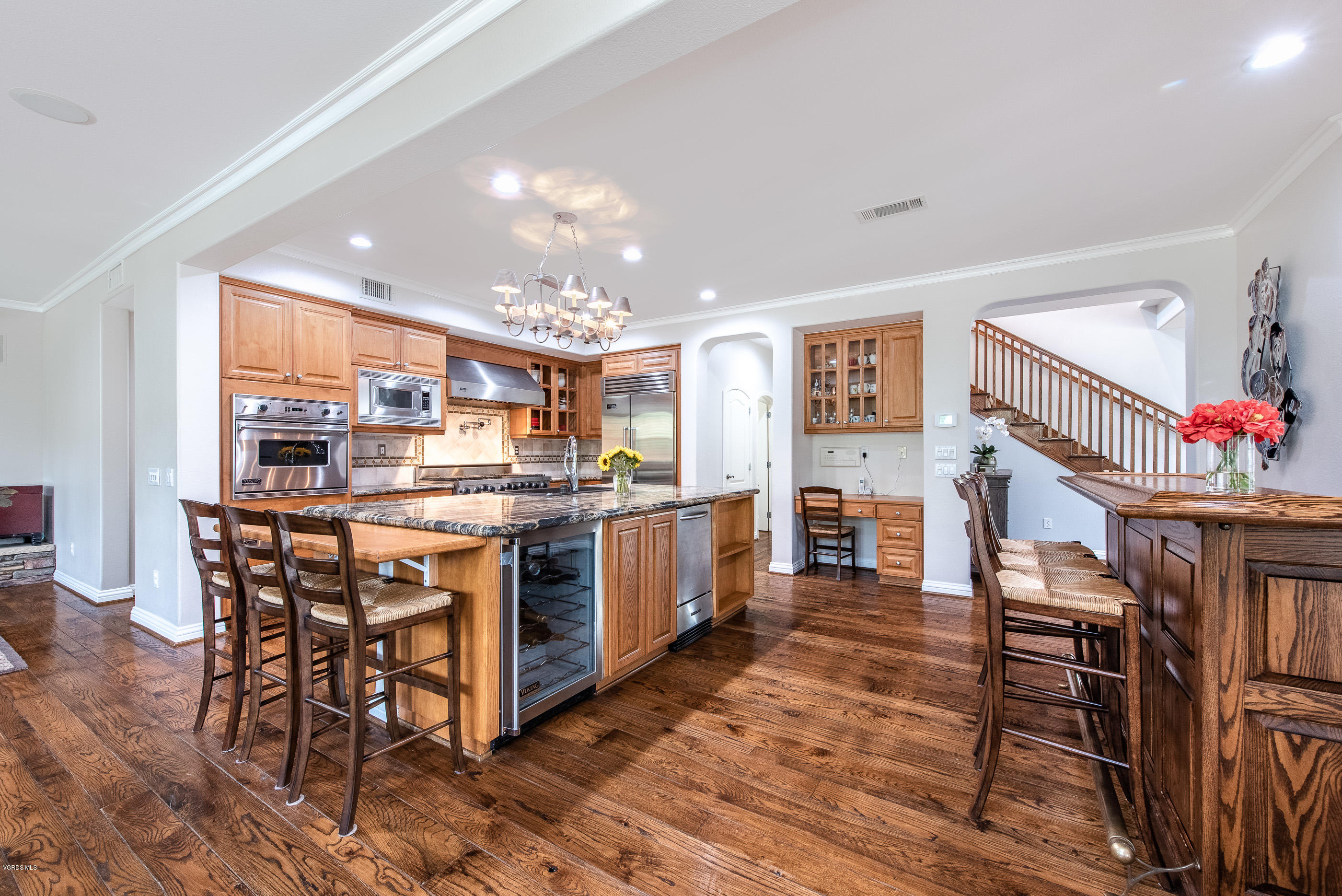 5635 Evening Sky Drive Simi Valley, CA 93063 - Photo 28 of 84 a kitchen with stainless steel appliances kitchen island granite countertop a table chairs and a refrigerator
