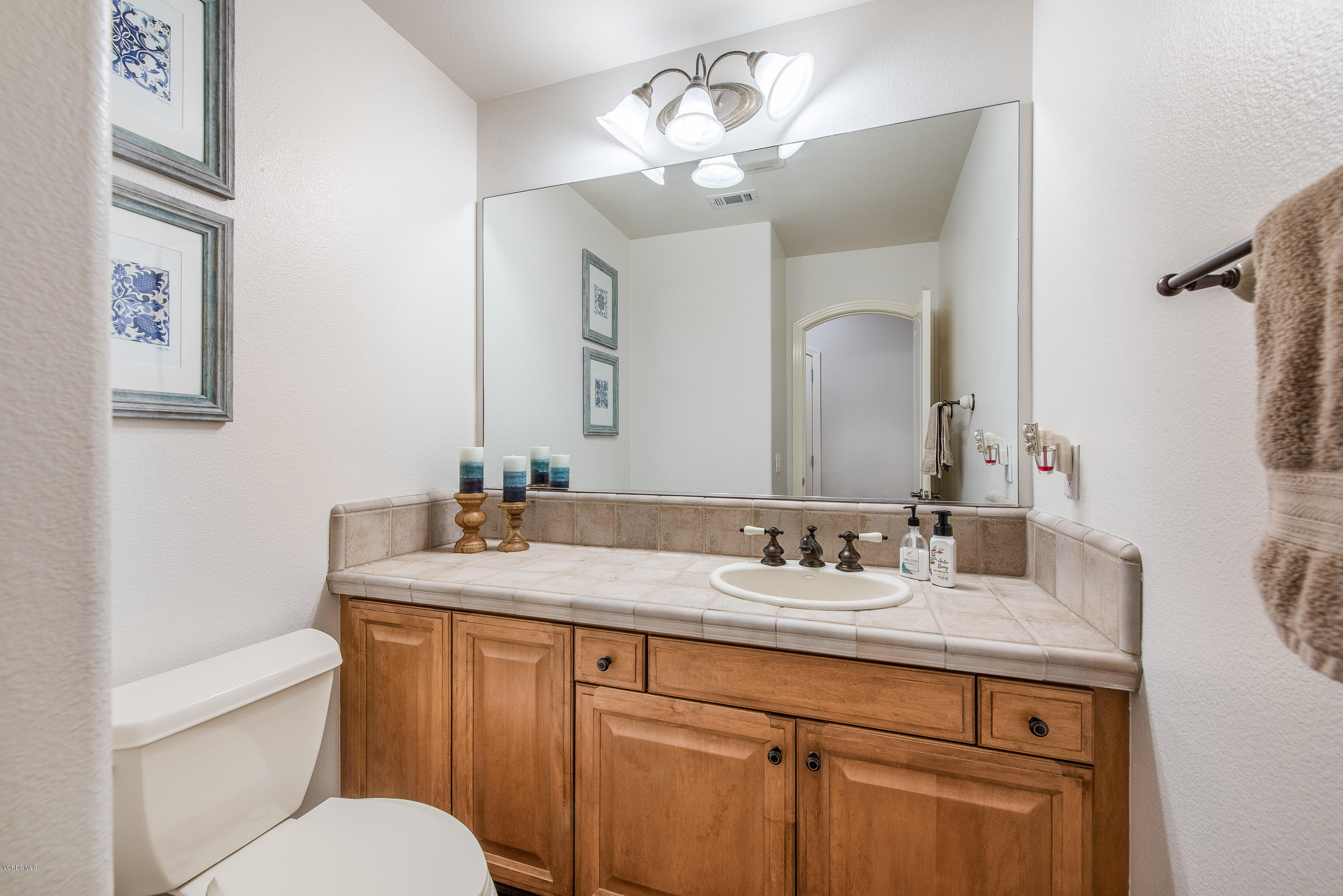 5635 Evening Sky Drive Simi Valley, CA 93063 - Photo 35 of 84 a bathroom with a granite countertop sink a toilet and a mirror
