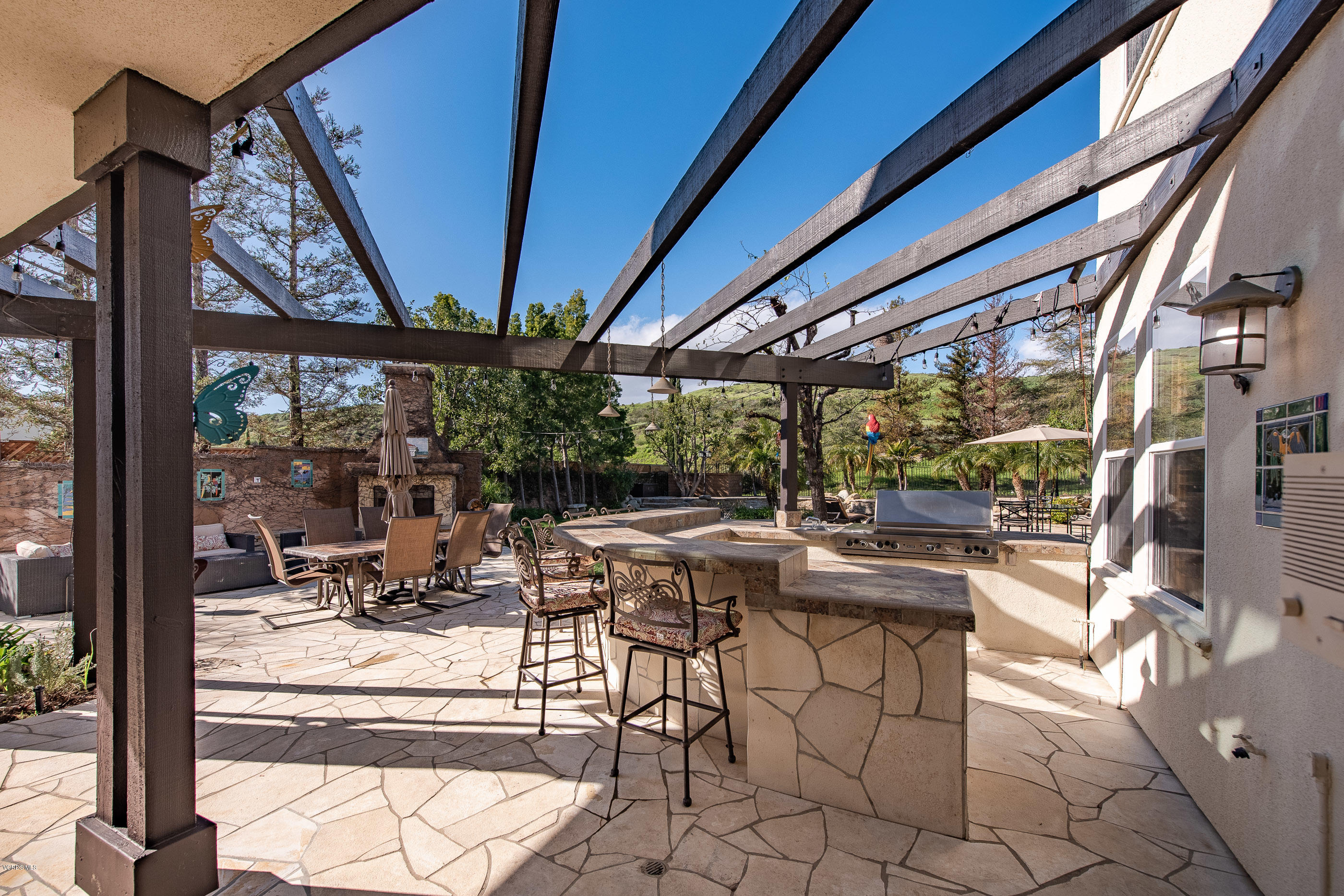 5635 Evening Sky Drive Simi Valley, CA 93063 - Photo 66 of 84 a view of a patio with table and chairs potted plants with wooden floor and floor to ceiling window