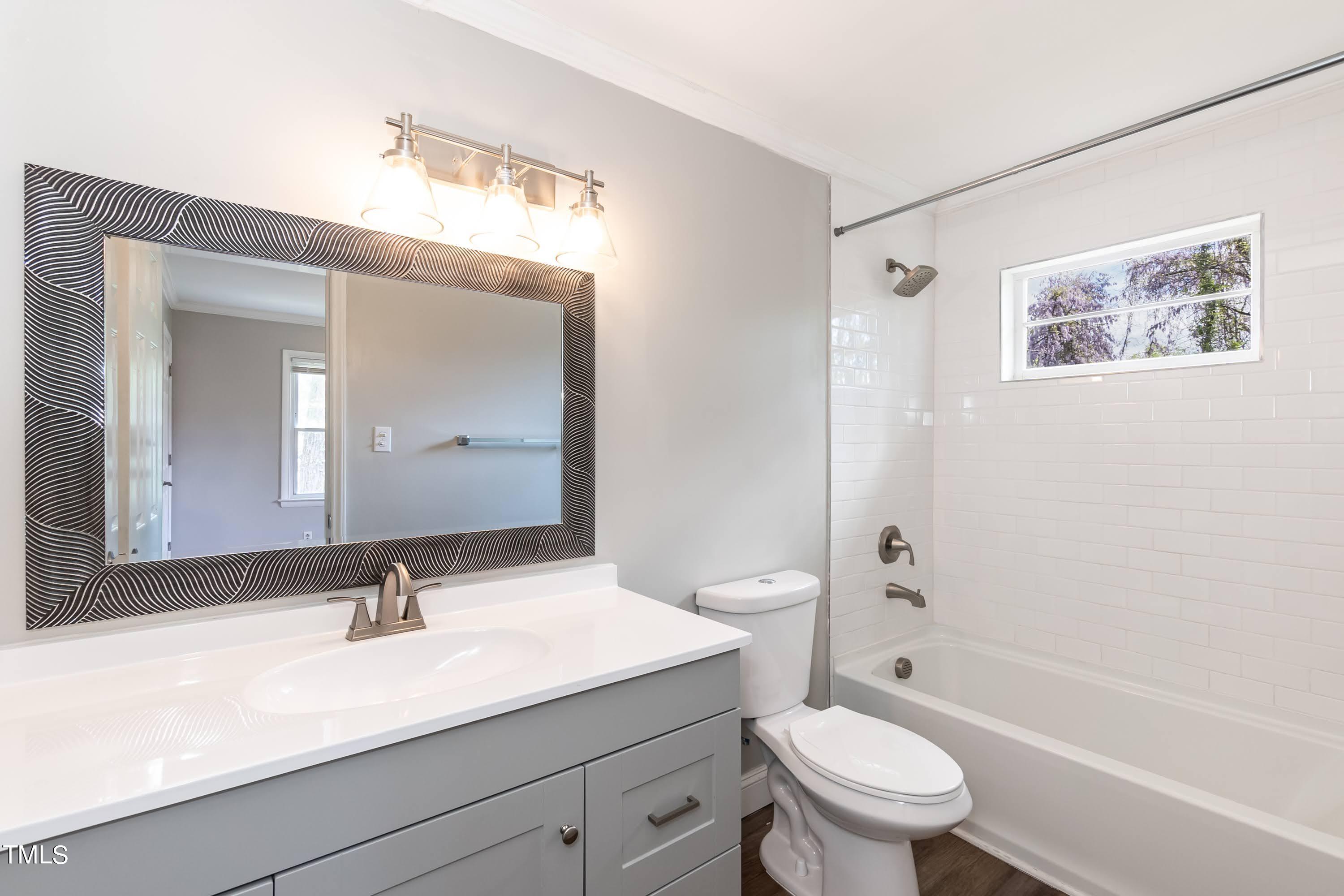 2019 Highway 55 Durham, NC 27707 - Photo 14 of 34 a bathroom with a granite countertop sink toilet a large mirror a shower and a bathtub