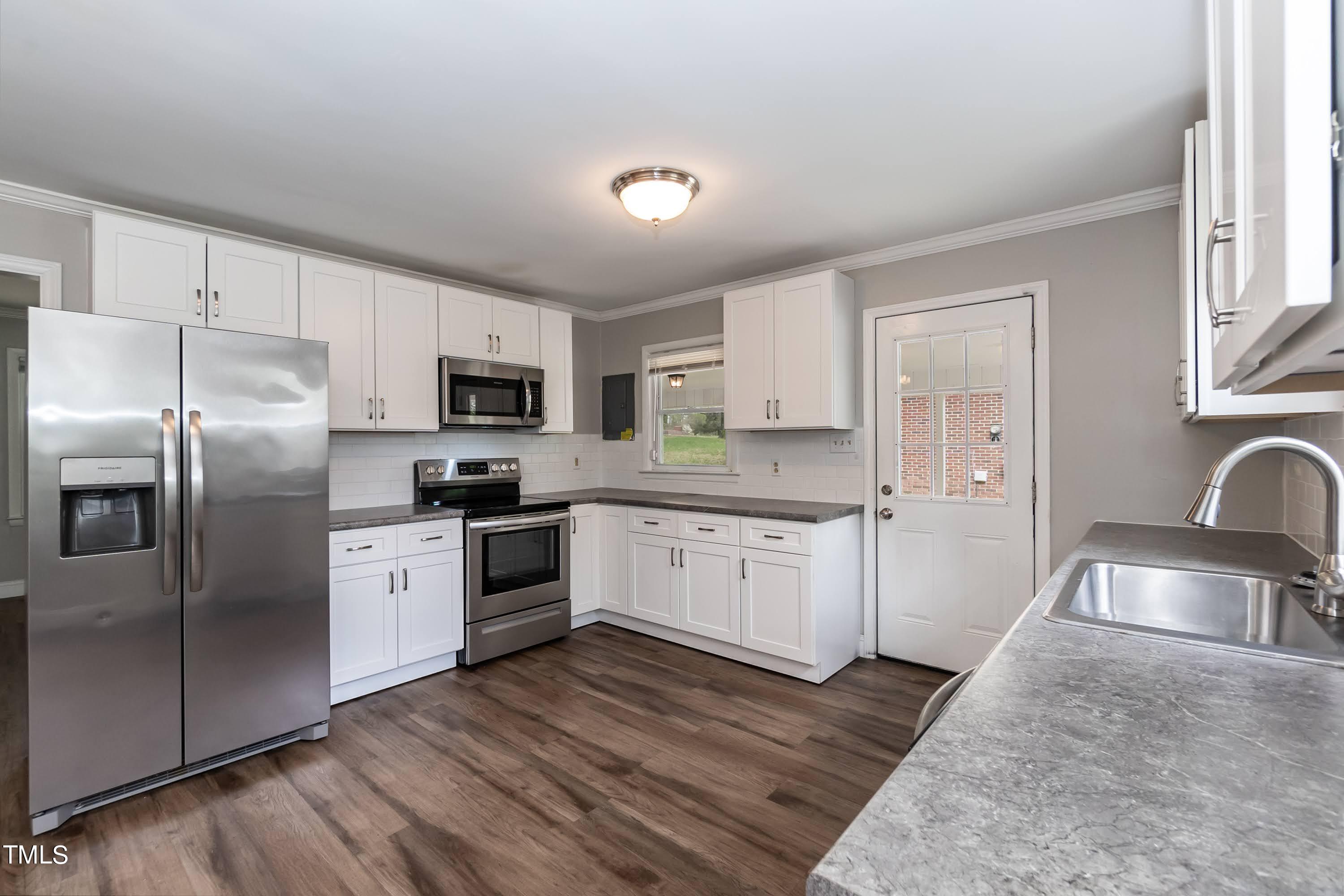 2019 Highway 55 Durham, NC 27707 - Photo 7 of 34 a kitchen with granite countertop a refrigerator oven a sink dishwasher and white cabinets with wooden floor