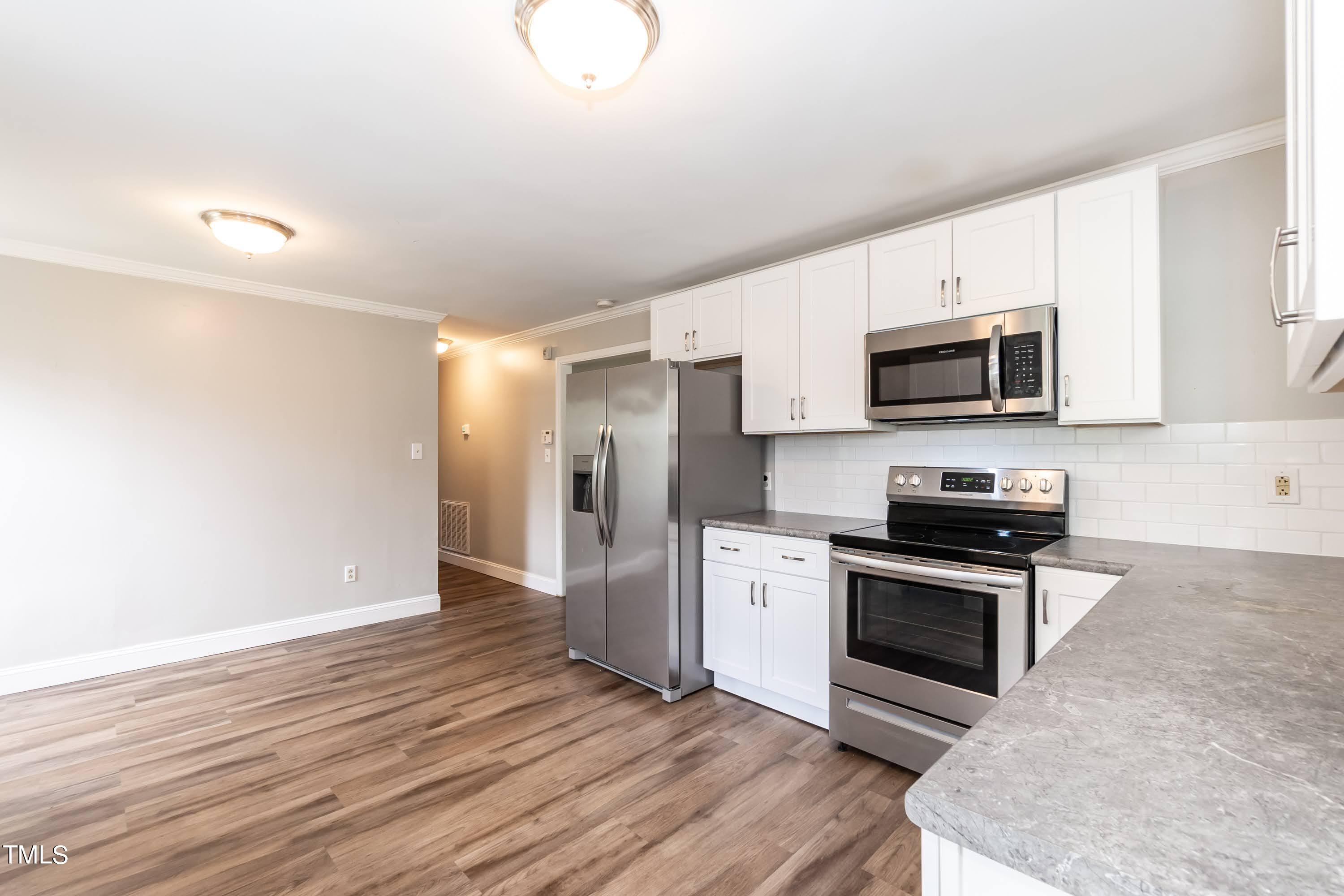 2019 Highway 55 Durham, NC 27707 - Photo 8 of 34 a kitchen with stainless steel appliances granite countertop a stove a sink and a microwave