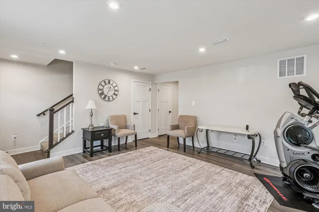 a living room with furniture a clock and a table