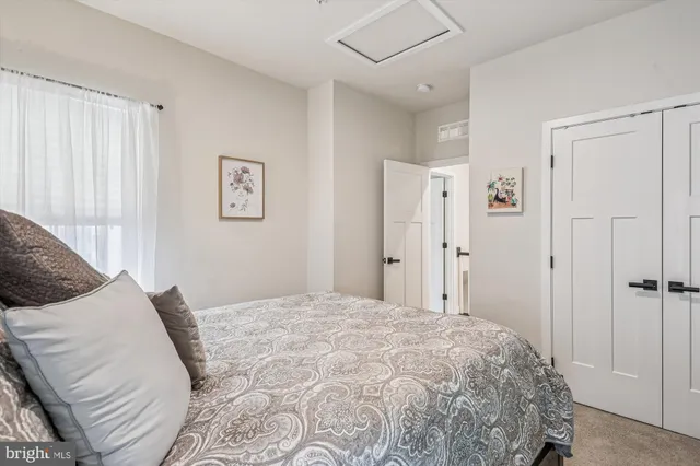 a bedroom with a large bed and a chandelier