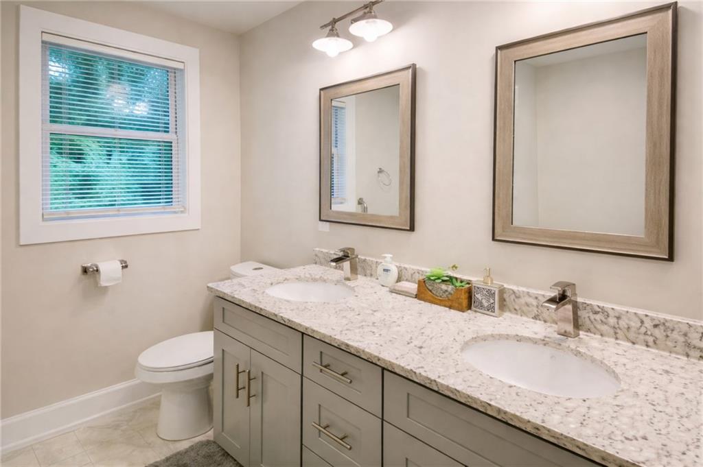 2130 Seavey Drive Decatur, GA 30032 - Photo 11 of 16 a bathroom with a granite countertop sink a toilet and a mirror