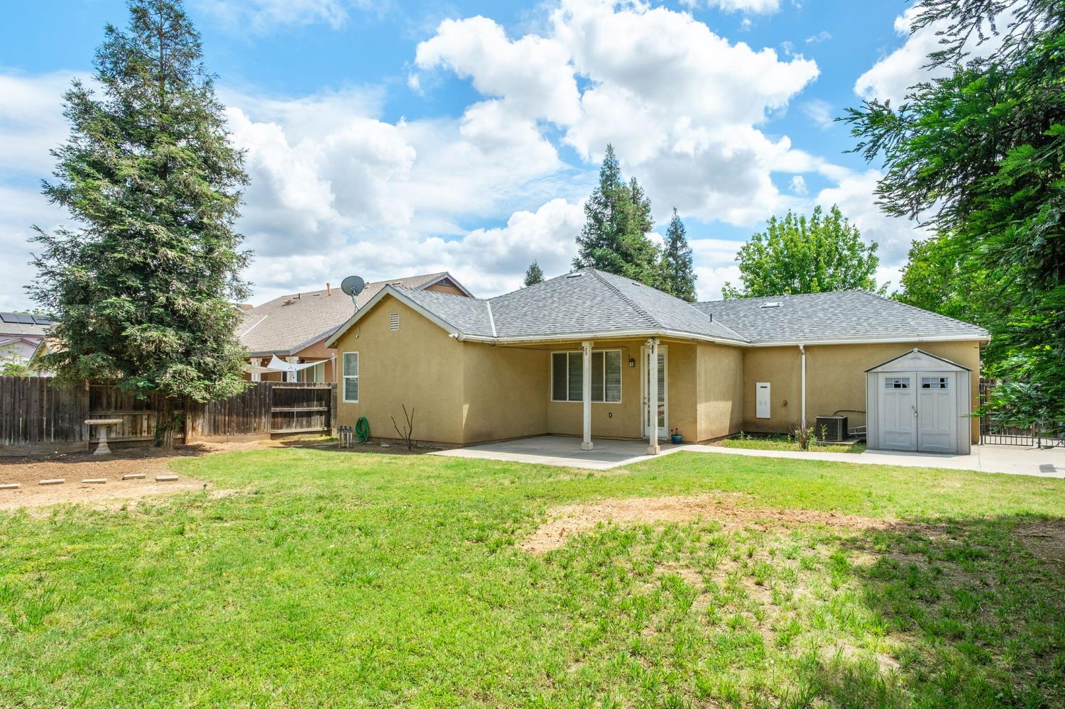 454 Sierra Avenue Reedley, CA 93654 - Photo 24 of 25 a front view of a house with a big yard and potted plants