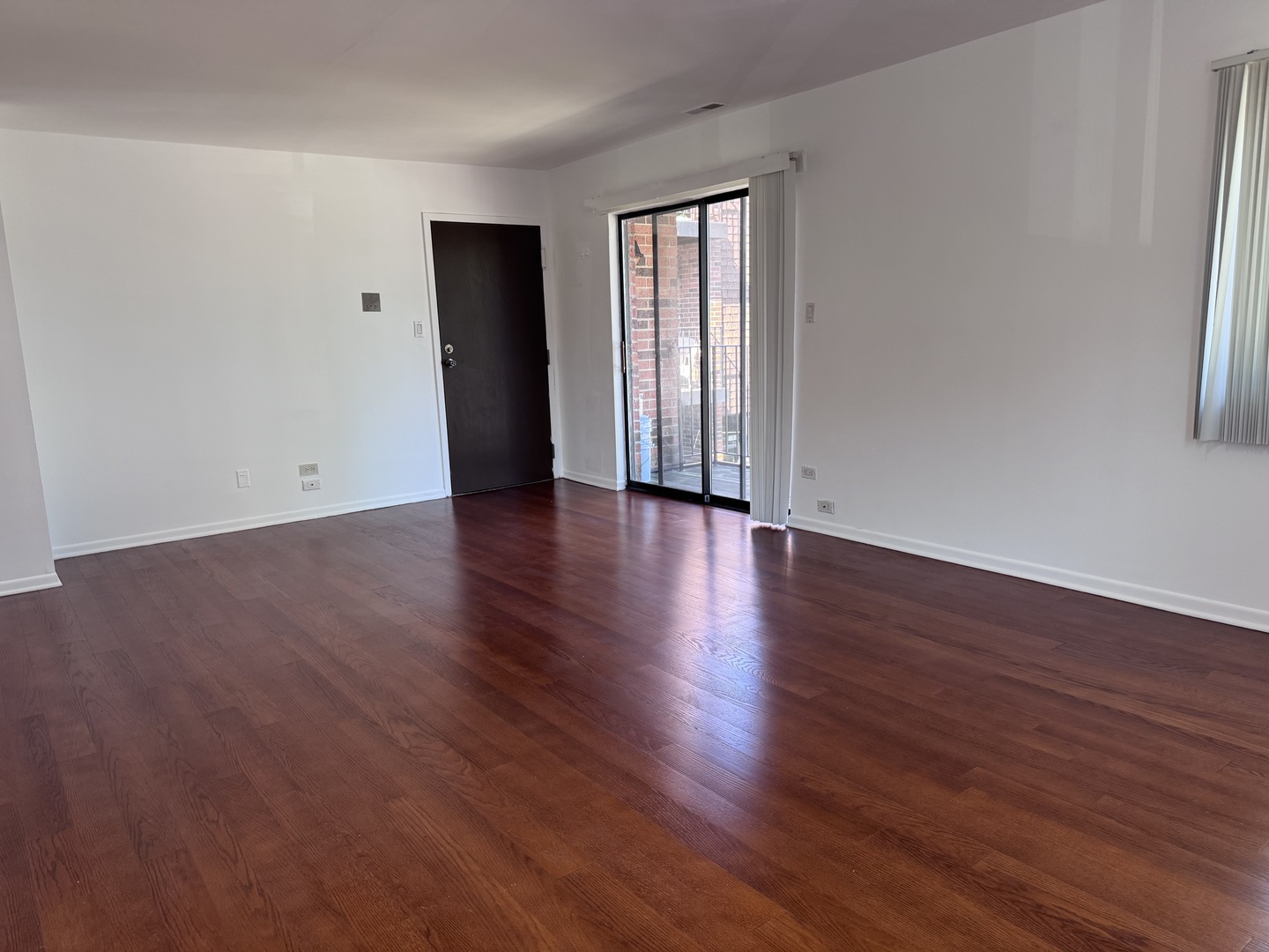 1785 West Algonquin Road, Unit 2A Mount Prospect, IL 60056 - Photo 6 of 14 a view of an empty room with wooden floor and a window