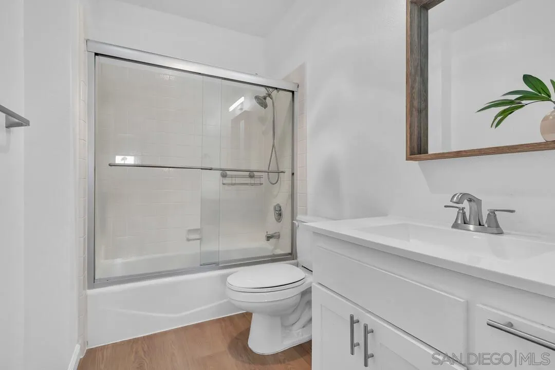 12027 Royal Road, Unit 3 El Cajon, CA 92021 - Photo 23 of 30 a bathroom with a granite countertop sink toilet a mirror and shower