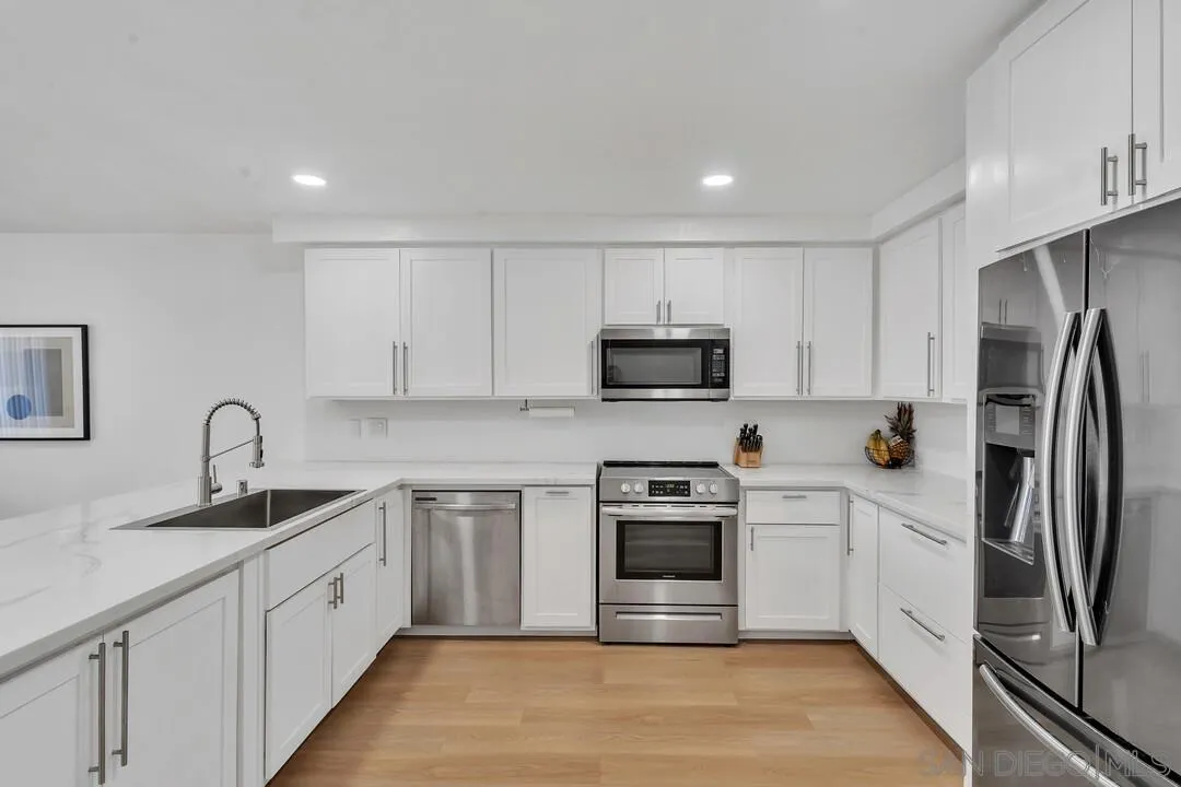 12027 Royal Road, Unit 3 El Cajon, CA 92021 - Photo 6 of 30 a kitchen with white cabinets stainless steel appliances and a sink