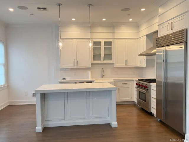a kitchen with a sink stainless steel appliances and white cabinets