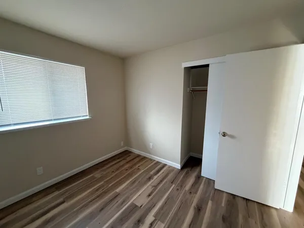 a view of a room with wooden floor and a window