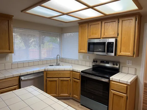 a kitchen with a sink stove top oven and cabinets
