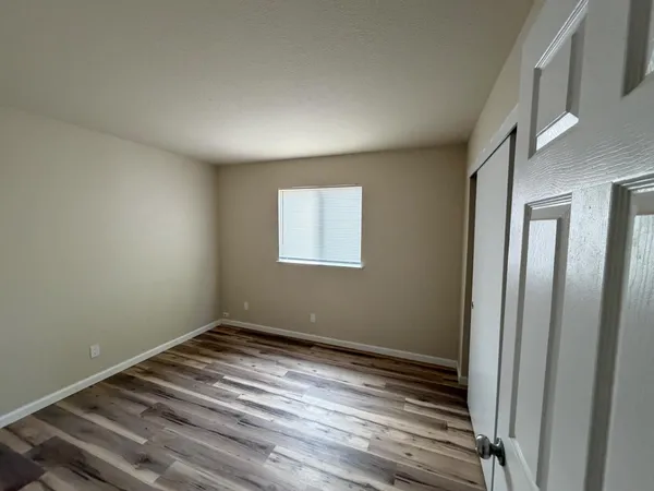a view of a room with wooden floor and window